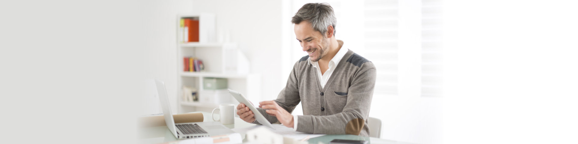 adult man smiling using tablet